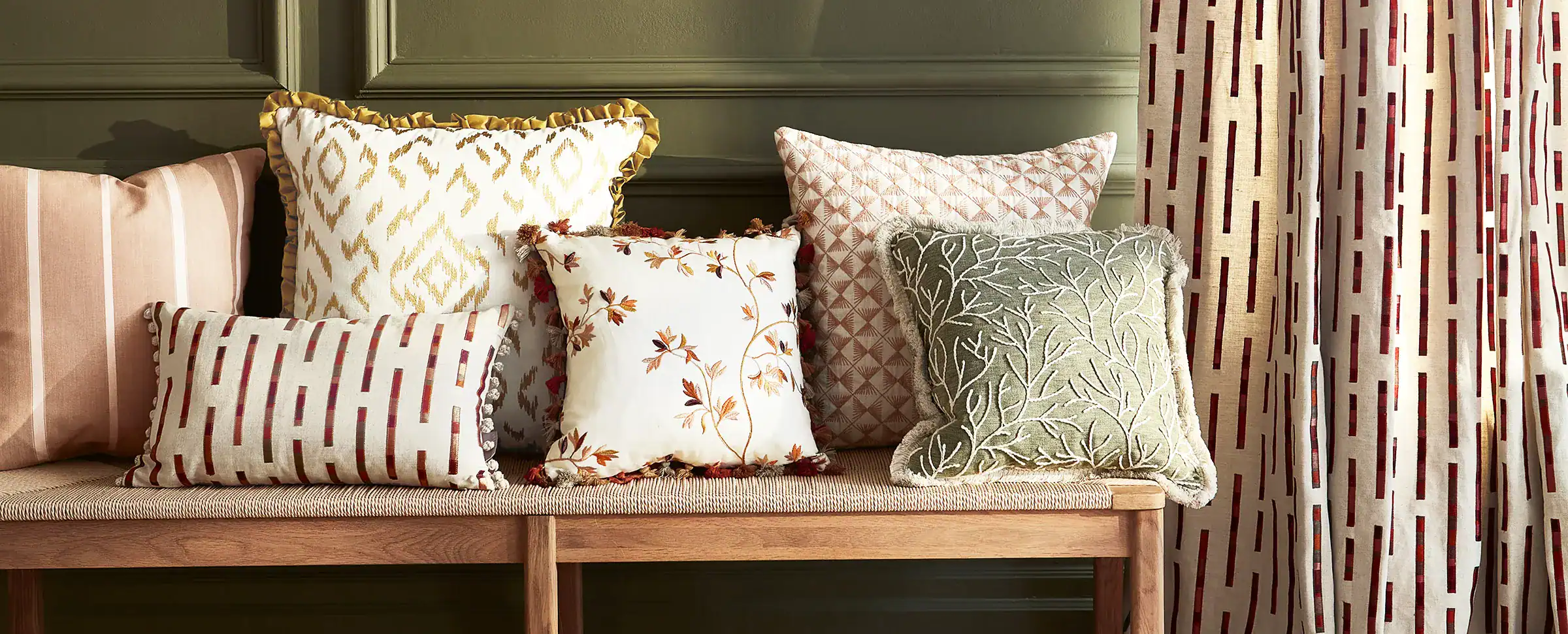 Verschiedene Kissen auf einer Bank.